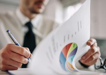 close-up-entrepreneur-going-through-business-reports-taking-notes-office (1)